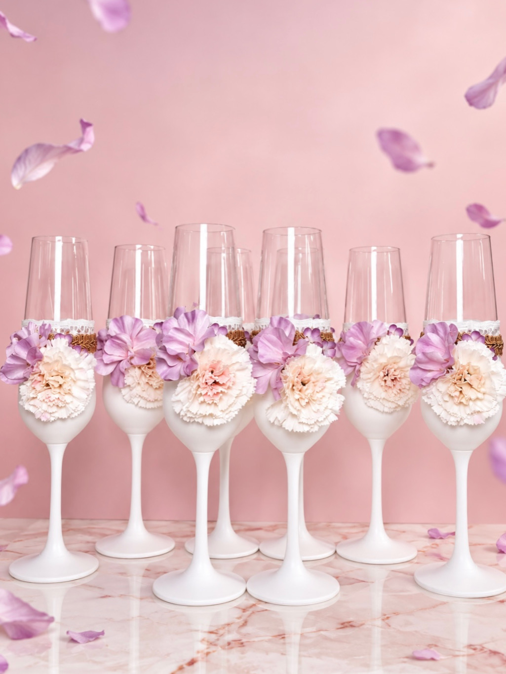 Juego de copas blancas decoradas con flores lilas y marfil sobre fondo rosa